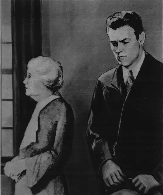 A man is holding onto is hat with his face down, and an elderly woman is standing beside him parallel to a window.