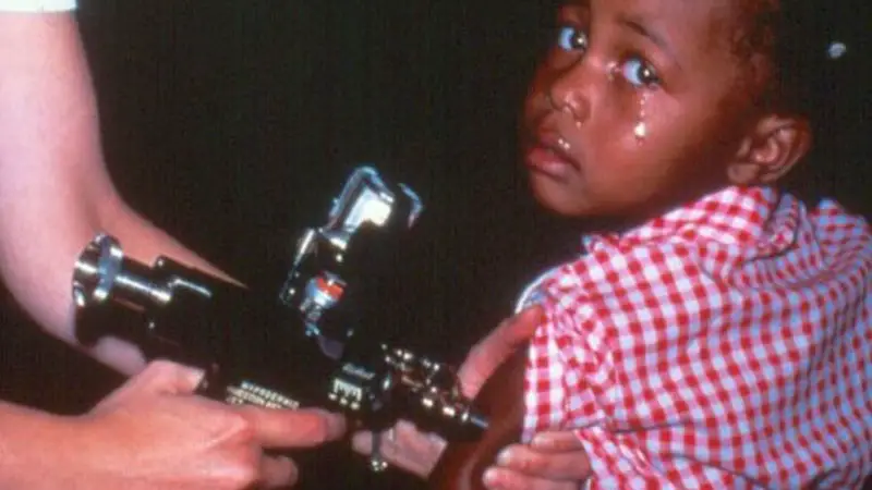 a child crying while getting vaccination shot